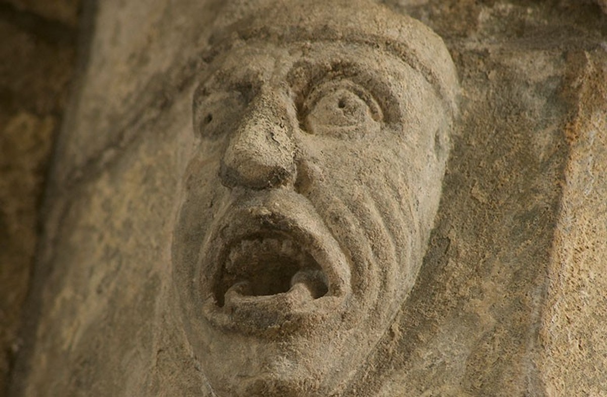Das Gesicht eines Mannes, das in den westlichen Kreuzbogen im Chor der Abtei von Iona eingemeisselt ist. Es gibt keinen Hinweis darauf, dass es sich um St. Oran handelt, aber es scheint eine sehr gena ...