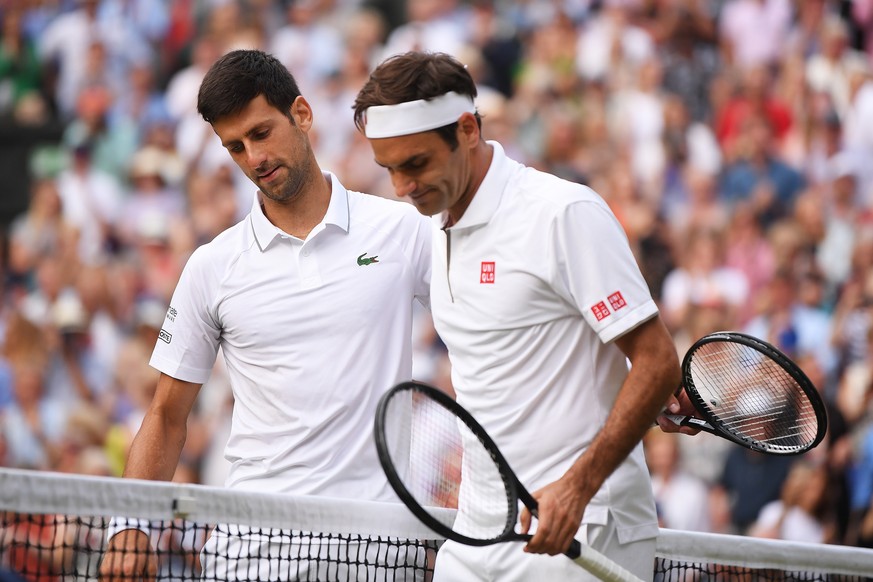 epa07717347 Novak Djokovic (L) of Serbia celebrates winning against Roger Federer (R) of Switzerland during their Men&#039;s final match for the Wimbledon Championships at the All England Lawn Tennis  ...