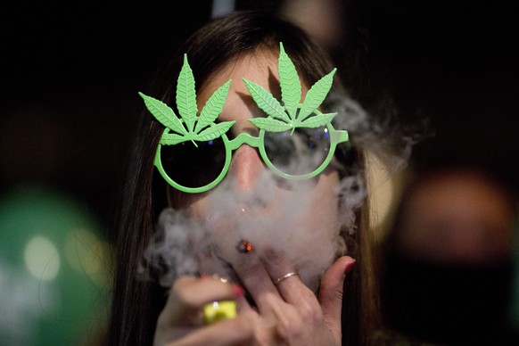 epa05771834 An Israeli woman smokes marijuana during a demonstration calling for the legalization of cannabis in Rabin Square, Tel Aviv, Israel, 04 February 2017. Thousands of people took part in a de ...