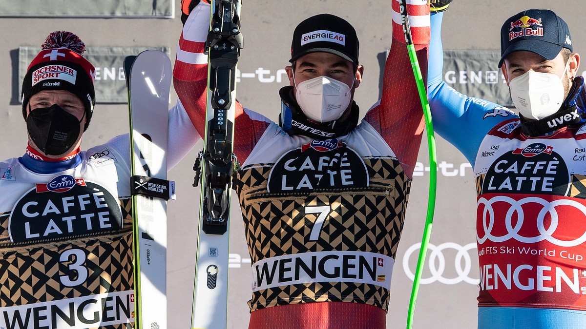epa09687121 Winner Vincent Kriechmayr (C) of Austria, second placed Beat Feuz (L) of Switzerland and third placed Dominik Paris (R) of Italy celebrate on the podium for the Men's Downhill race at ...