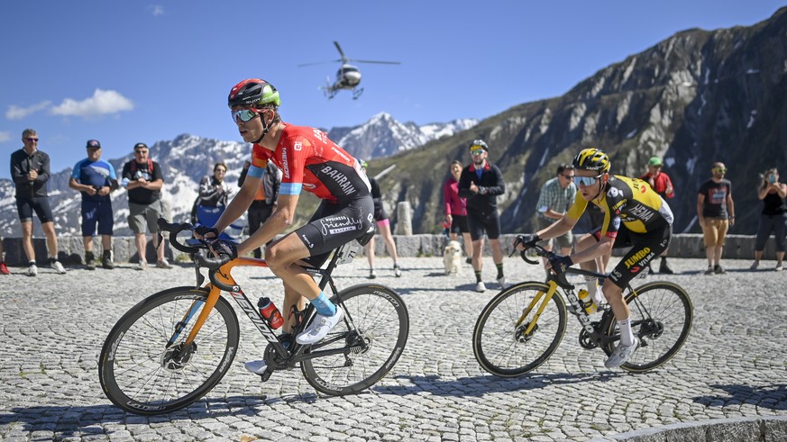 Gino Maeder from Switzerland of Bahrain Victorious, left, leads Sam Oomen from the Netherlands of Jumbo-Visma on their way to the Gotthard pass, during the eighth and final stage, a 160 km race with s ...
