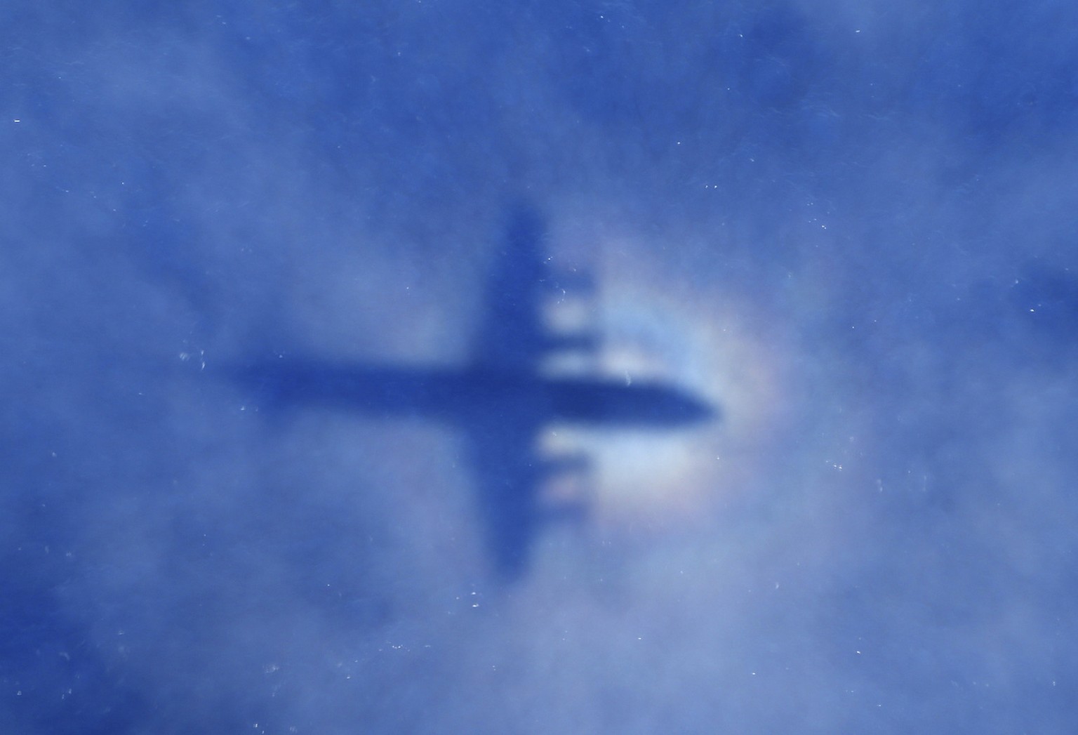 In this Monday, March 31, 2014 photo, a shadow of a Royal New Zealand Air Force P-3 Orion aircraft is seen on low cloud cover while it searches for missing Malaysia Airlines Flight MH370 in the southe ...