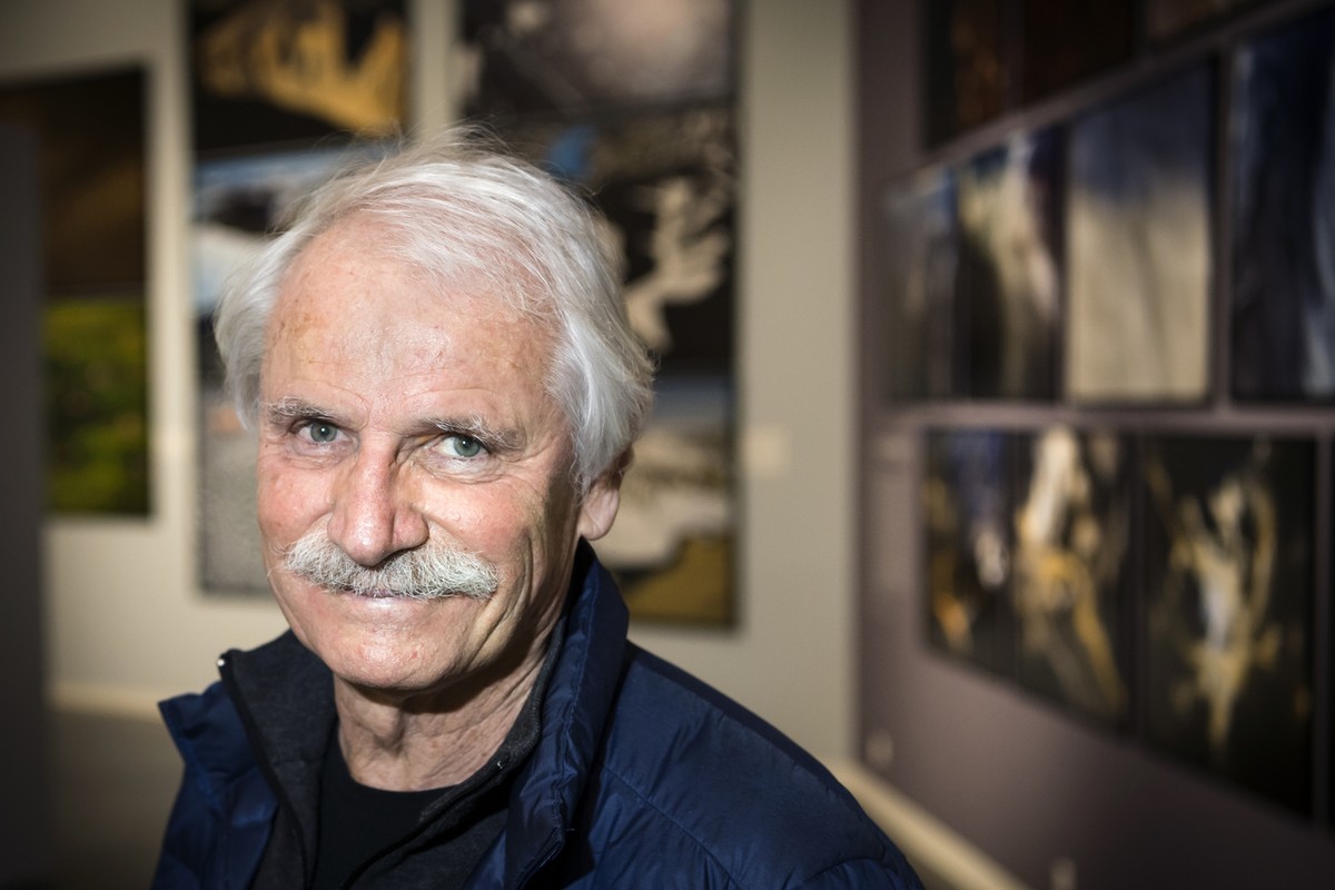 Le photographe Yann Arthus-Bertrand pose devant ses images lors de la premiere exposition de la Fondation Opale consacree a la retrospective du photographe Yann Arthus-Bertrand, "Legacy, une vie  ...