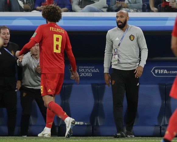 Belgium&#039;s Marouane Fellaini, left, walks off the pitch past assistant coach Thierry Henry to be replaced during the semifinal match between France and Belgium at the 2018 soccer World Cup in the  ...