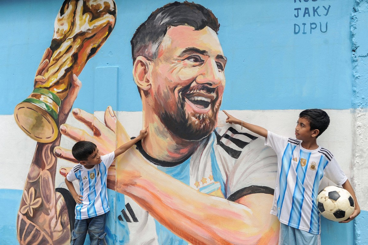 June 14, 2026: Sylhet, Bangladesh- Children wearing Argentina football jerseys gesture toward a mural of Argentine football player Lionel Messi in Sylhet, Bangladesh, on June 14, 2026. Football suppor ...
