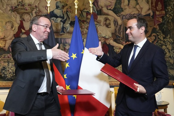 French Defense Minister Sebastien Lecornu , right, and his German counterpart Boris Pistorius shakes hands after signing an agreement in Paris Friday, April 26, 2024. The ministers ratified the divisi ...