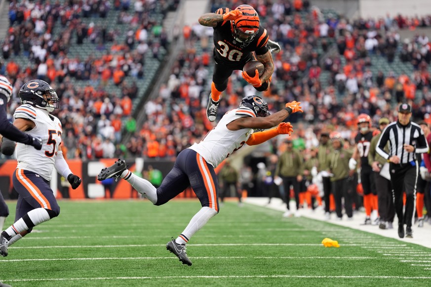 Cincinnati Bengals running back Chase Brown (30) hurdles Chicago Bears defensive back Kevin Byard III (31) on a run during an NFL football game, Sunday, Nov. 2, 2025, in Cincinnati. (AP Photo/Kareem E ...