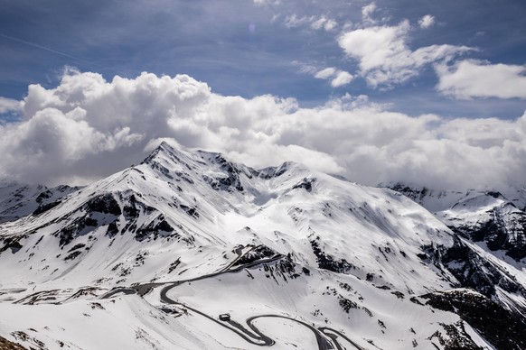 Scenic view of snow-covered mountain and winding road Breathtaking view of the snow-covered Grossglockner High Alpine Road winding through majestic mountains, showcasing a stunning national landmark i ...
