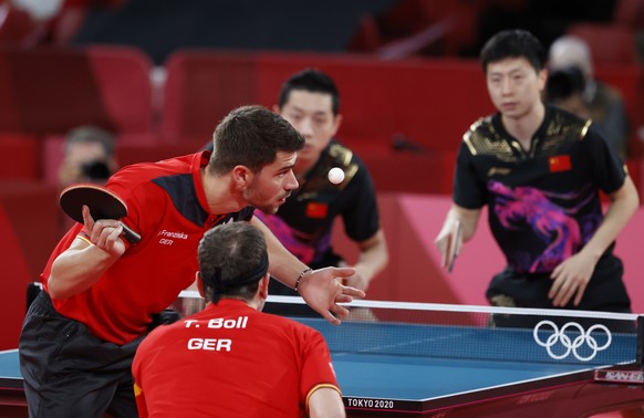 epa09400193 Timo Boll (R) und Patrick Franziska (R) of Germany in action during the Table Tennis men&#039;s team cold medal match against Ma Long and Xu Xin of China during the Tokyo 2020 Olympic Game ...