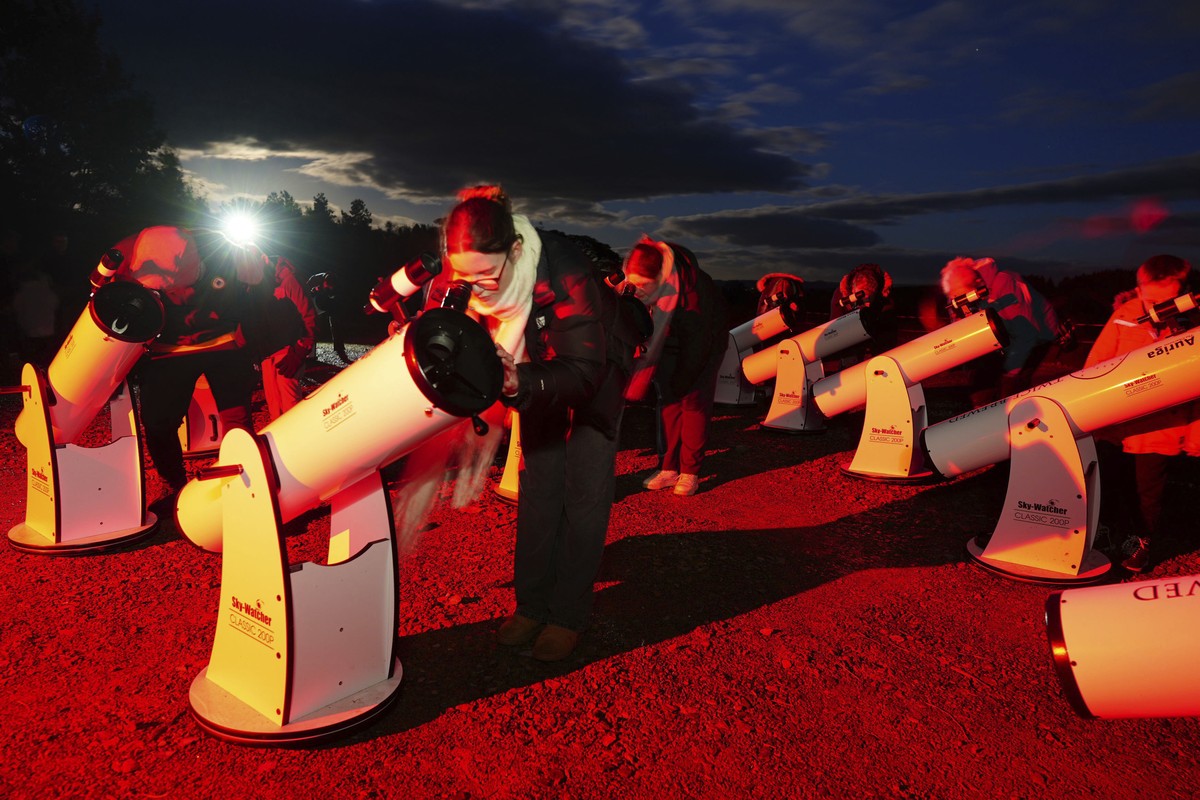 A group of stargazers use telescopes to catch a glimpse of the Comet A3, also known as the Tsuchinshan-Atlas, and the full moon in the skies above the Twice Brewed Inn in the Northumberland Internatio ...