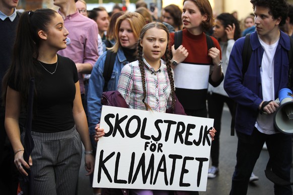 Swedish teenager Greta Thunberg, center, leads a march of thousands of French students through Paris, France, to draw more attention to fighting climate change, Friday, Feb. 22, 2019. Sign reads : &qu ...