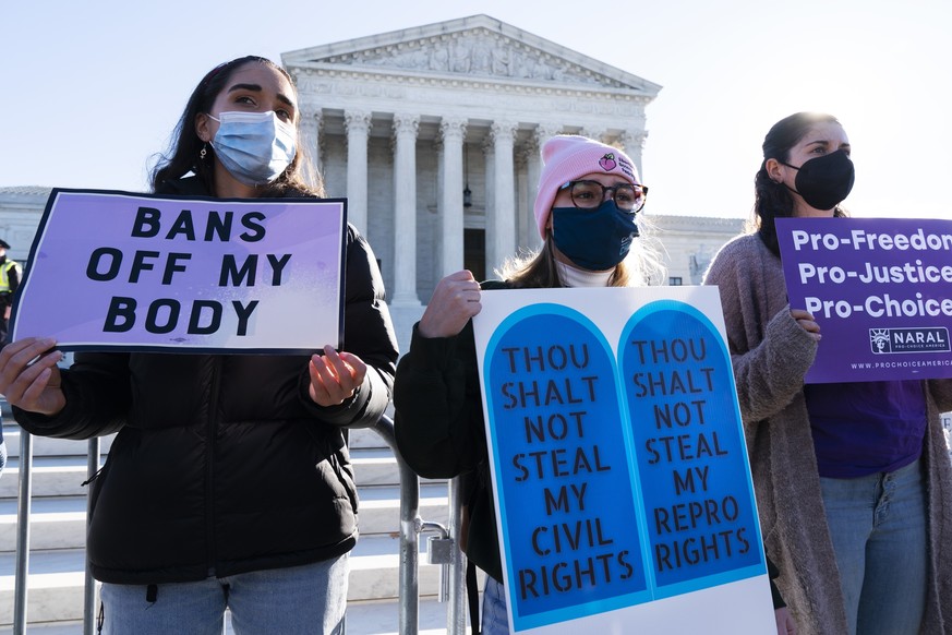 FILE - Caroline McDonald, left, a student at Georgetown University, Lauren Morrissey, with Catholics for Choice, and Pamela Huber, of Washington, join a abortion-rights rally outside the Supreme Court ...