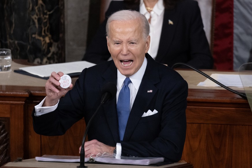 epa11205903 US President Joe Biden holds a pin referring to slain Georgia student Laken Riley; while delivering his State of the Union address before a joint session of Congress on the floor of the US ...