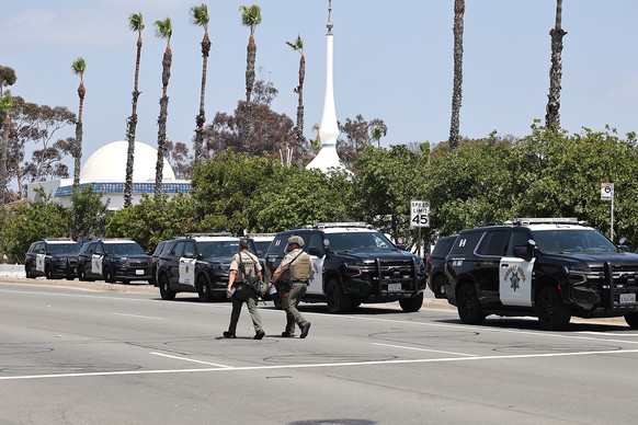 epa12972643 Law enforcement personnel gather on the scene to respond to an active shooting incident at the Islamic Center of San Diego, located in the Clairemont neighborhood in San Diego, California, ...