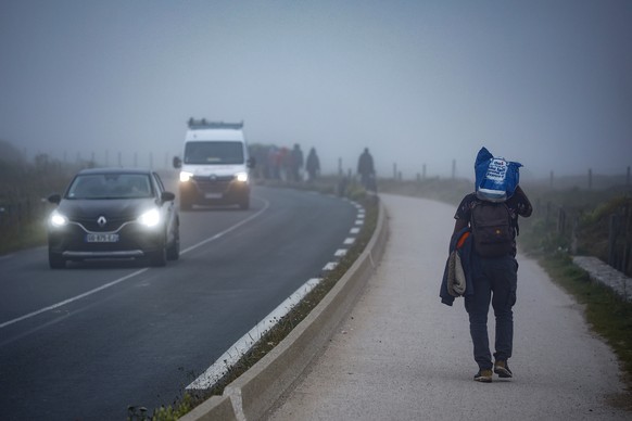 epa12244846 Migrants walk along the road early morning after attempting to cross the English Channel outside Wimereux, north of France, 18 July 2025. On July 10, 2025, during President Macron&#039;s s ...