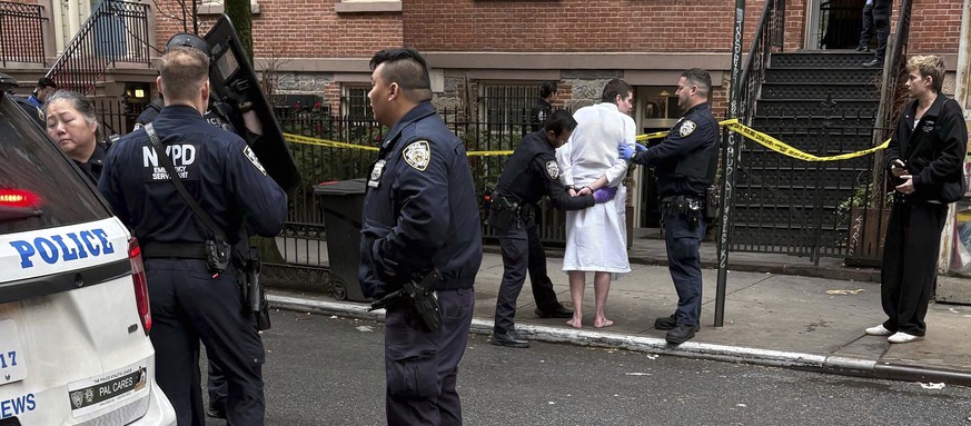 New York police officers arrest John Woeltz, Friday, May 23, 2025, in New York, who was charged with kidnapping, assaulting and holding a man against his will for several weeks in an upscale Manhattan ...