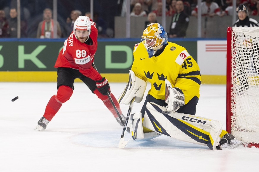 epa13001214 Switzerland's Christoph Bertschy (L) vies for the puck against Sweden's goaltender Magnus Hellberg during the 2026 IIHF Men's Ice Hockey World Championship Quarterfinal game ...