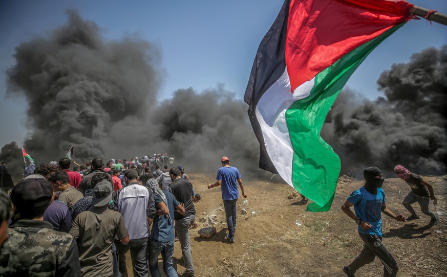 epaselect epa06737559 Palestinian protesters take part during clashes after protests near the border with Israel in the east of Gaza Strip, 14 May 2018 (issued 15 May 2018). More protests are expected ...