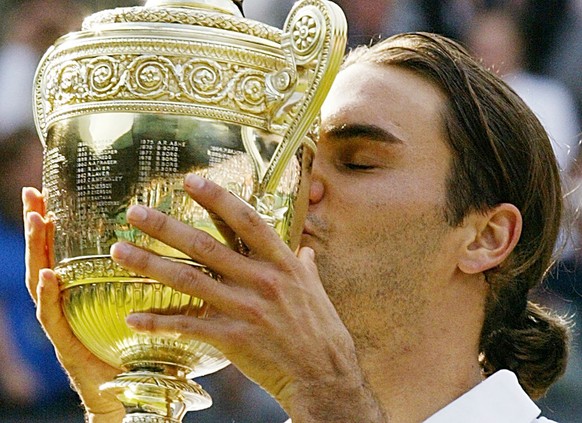 Roger Federer kisses the winner&#039;s trophy after winning the Men&#039;s Singles final on the Centre Court at Wimbledon, Sunday July 4, 2004. Federer won the match 4-6, 7-5, 7-6 (3), 6-4, to retain  ...