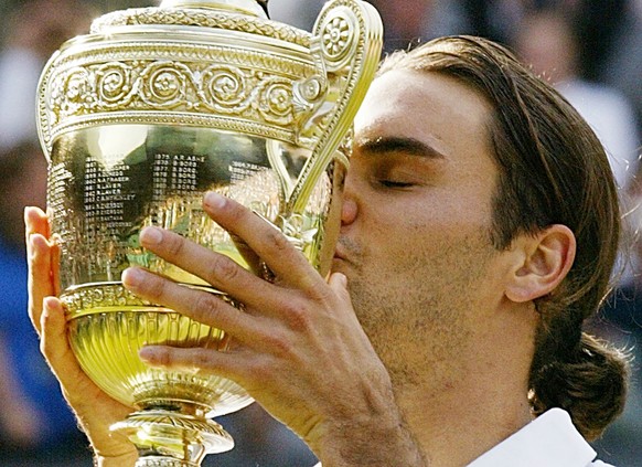 Roger Federer kisses the winner's trophy after winning the Men's Singles final on the Centre Court at Wimbledon, Sunday July 4, 2004. Federer won the match 4-6, 7-5, 7-6 (3), 6-4, to retain ...