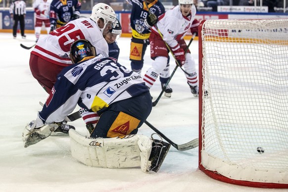 Lausannes Tyler Moy, links, im Spiel gegen Zugs Torhueter Leonardo Genoni, rechts, beim Eishockey Meisterschaftsspiel der National League zwischen dem EV Zug und dem Lausanne HC, am Dienstag, 17. Sept ...