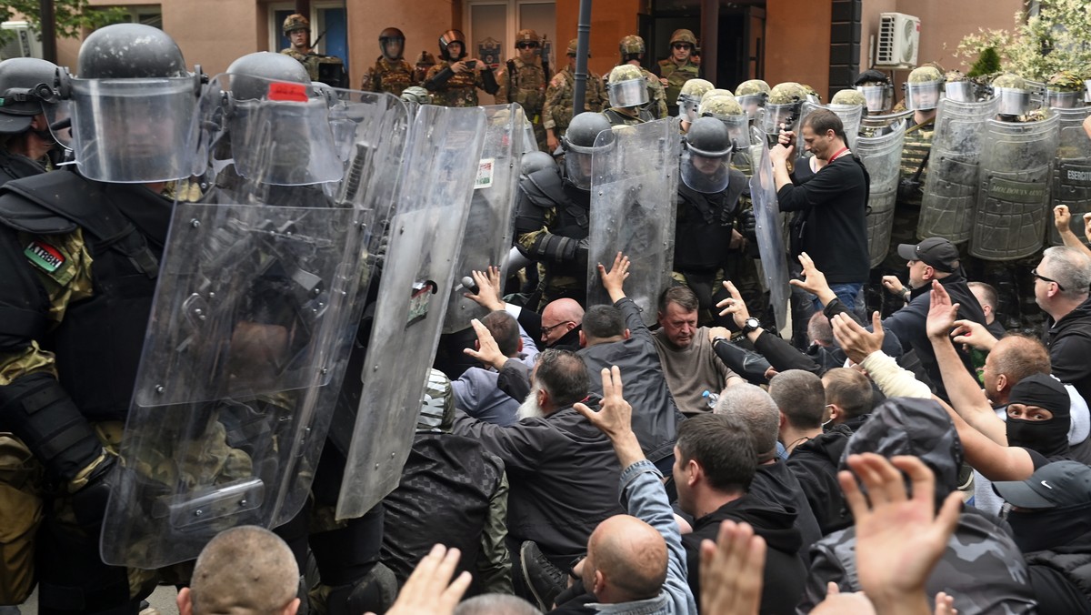 epaselect epa10662176 Ethnic Serbs sit on the street in front of the cordon of soldiers of NATO-led international peacekeeping Kosovo Force (KFOR) in front of the building of the municipality in Zveca ...