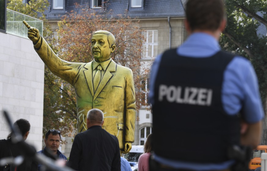 Police and passersby surround a statue showing Turkish President Erdogan which is part of the art festival &#039;Wiesbaden Biennale&#039; in Wiesbaden, western Germany, Tuesday, Aug. 28, 2018. (Arne D ...
