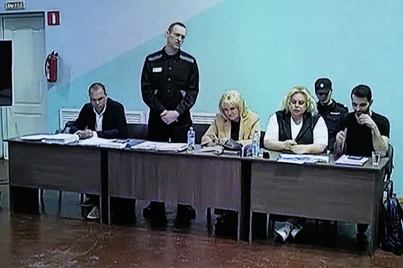 A view of a TV Screen showing Russian opposition leader Alexei Navalny, 2nd left, between his lawyers in a courtroom, via video link provided by the Russian Federal Penitentiary Service, during a prel ...