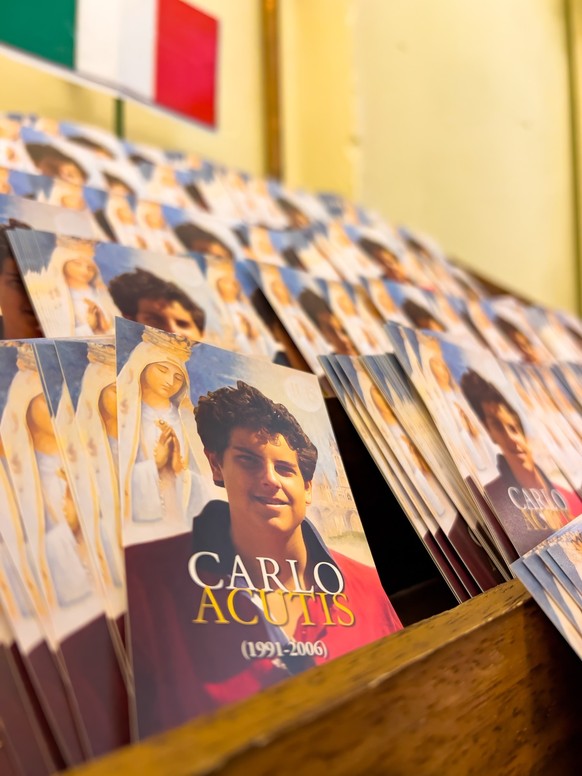 Kleine Plakate von Carlo Acutis mit dem Gebet zu ihm auf der Rückseite.