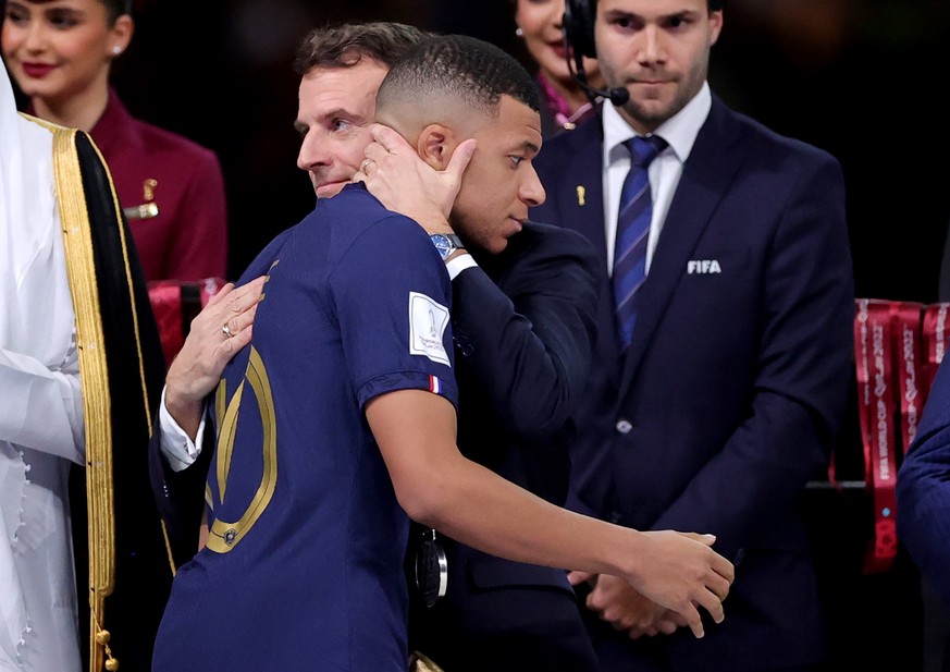 epa10373181 French President Emmanuel Macron hugs French forward Kylian Mbappe after the FIFA World Cup 2022 Final between Argentina and France at Lusail stadium, Lusail, Qatar, 18 December 2022. Arge ...