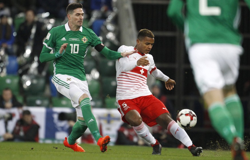 Northern Ireland's Kyle Lafferty, left, challenges Switzerland's Manuel Akanji during the World Cup qualifying play-off first leg soccer match between Northern Ireland and Switzerland at Windsor Park  ...