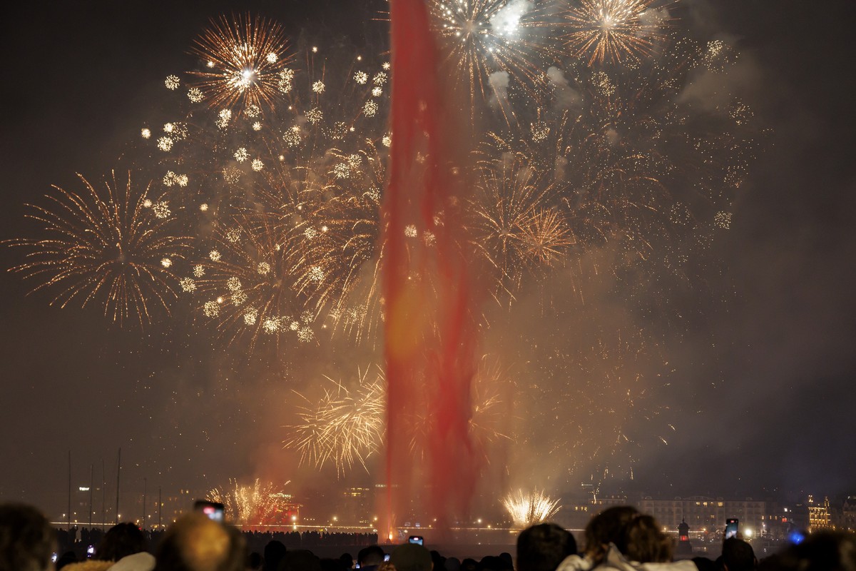 epa11051598 Fireworks illuminate the sky above the bay of Geneva behind the famous water fountain "Le Jet d'Eau" during New Year celebrations in Geneva, Switzerland, 01 January 2024. EP ...