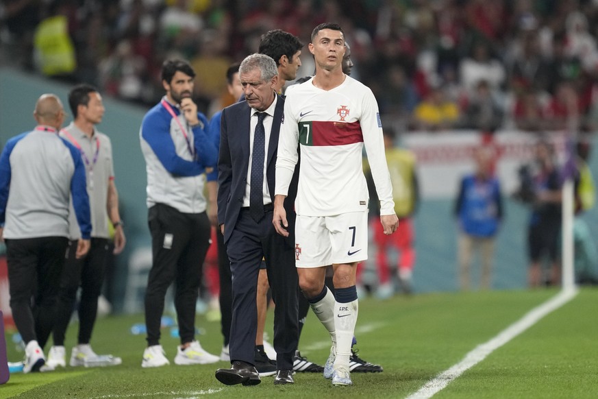 Portugal's Cristiano Ronaldo, center, passes beside his coach Fernando Santos as he leaves the field during the World Cup group H soccer match between South Korea and Portugal, at the Education City S ...