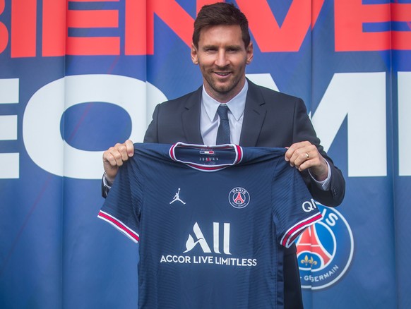 epa09409575 Argentinian striker Lionel Messi poses with his new PSG jersey after his press conference as part of his official presentation at the Parc des Princes stadium, in Paris, France, 11 August  ...