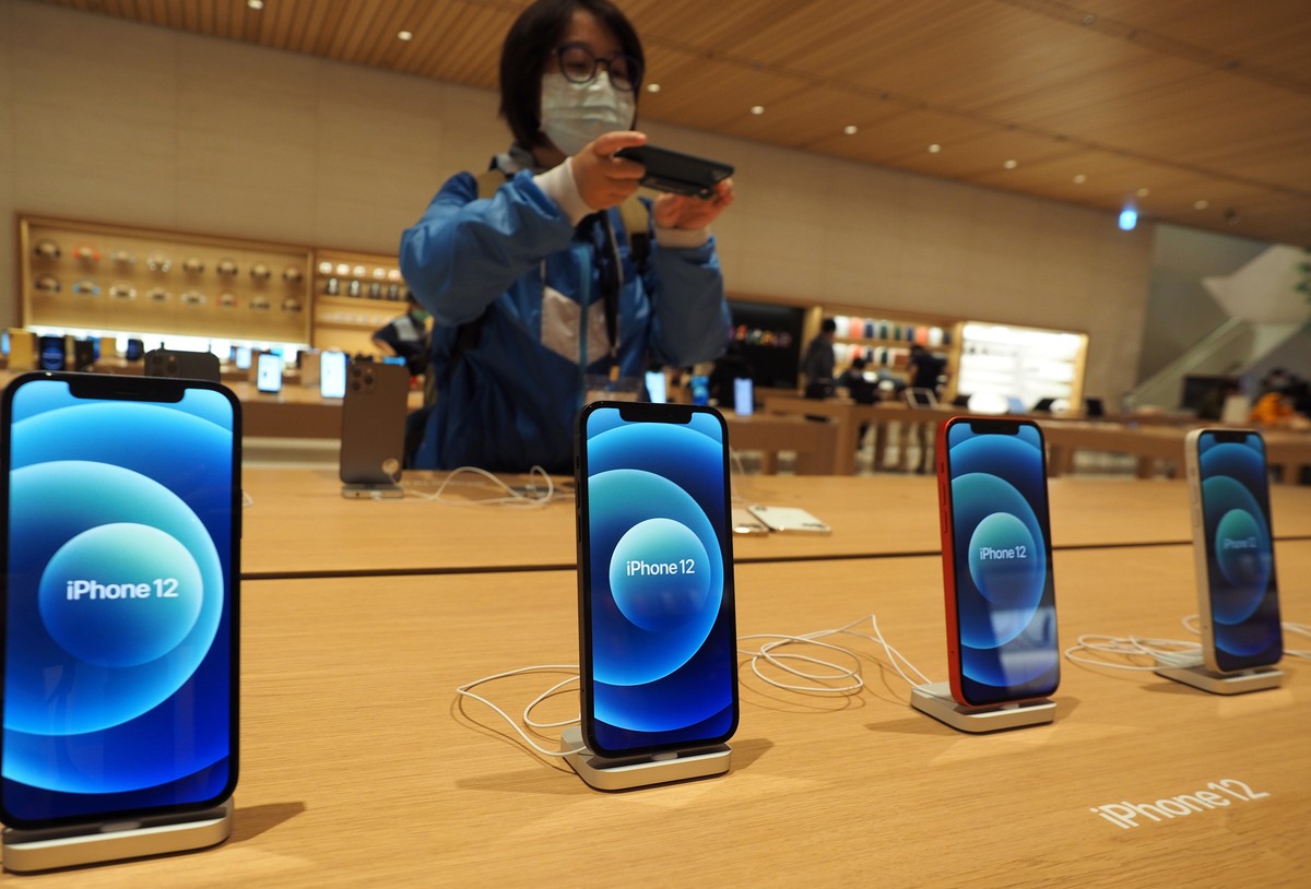 epa08767260 A woman takes photographs of iPhone 12 smartphones in a mobile store in Taipei, Taiwan, 23 October 2020. On 23 October, Apple launched the iPhone 12 and iPhone 12 Pro in Taiwan. EPA/DAVID  ...