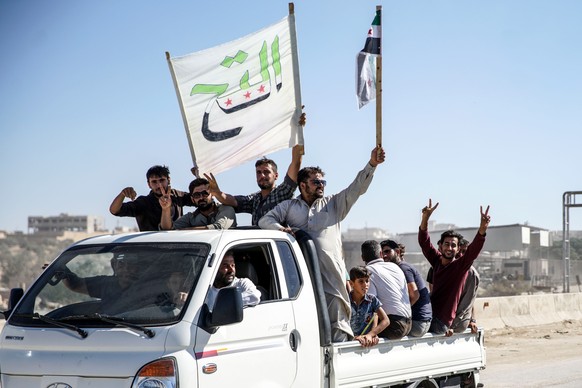 epa07020248 People carry syrian revolution flags and placards during protests in Kafr Nabl town, Maarrat al-Nu&#039;man District, rebels-held Idlib province, Syria, 14 September 2018. According to rep ...
