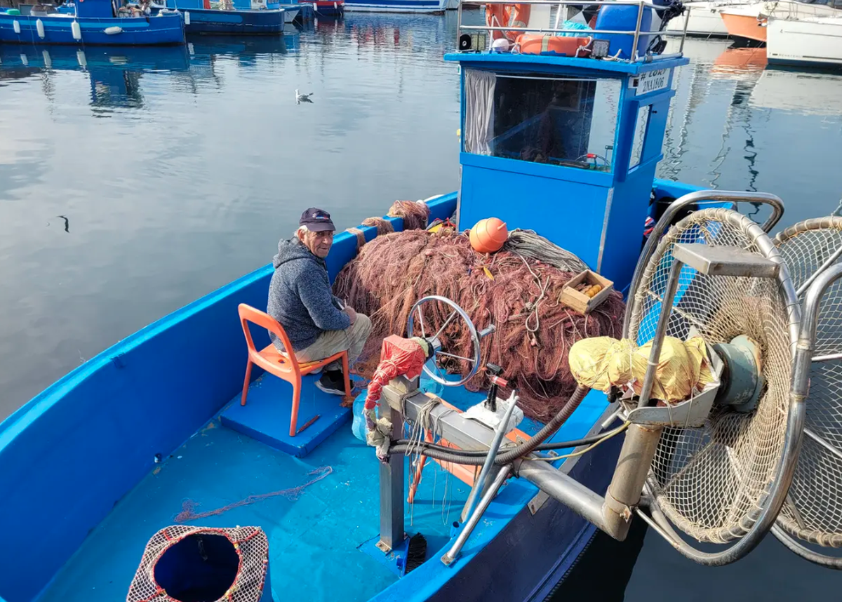 Pouzzoles: Le pêcheur Bruno répare ses filets - et se plaint du mur du port, qui dépasse désormais de trois mètres de l'eau.