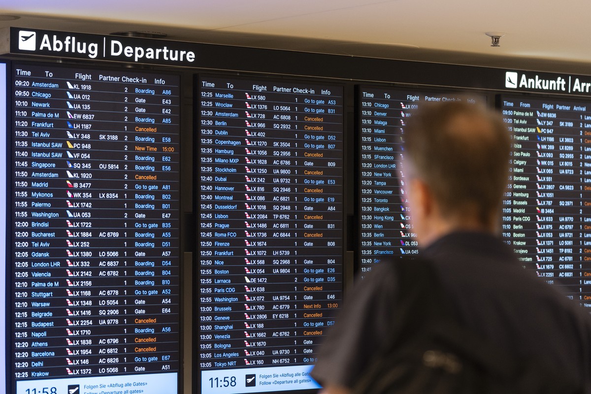 Passengers look at screens informing them of the flight situation, on Friday, 19 July 2024, at the airport Zurich in Kloten, Switzerland. Due to a worldwide IT breakdown, check-in for air travellers a ...