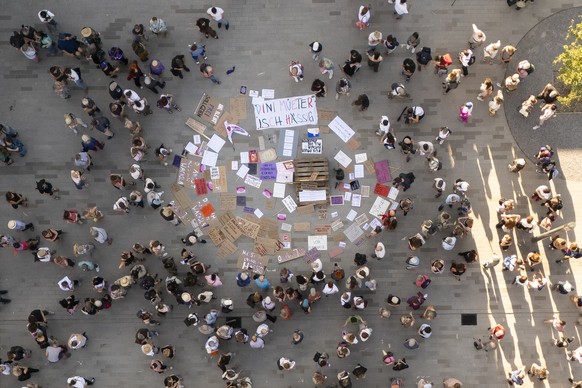 Teilnehmende bei einer Mahnwache gegen sexualisierte Gewalt betrachten die Plakate bei der Buehne, am Montag, 27. Juli 2026 in Untersiggenthal. (KEYSTONE/Andreas Becker)