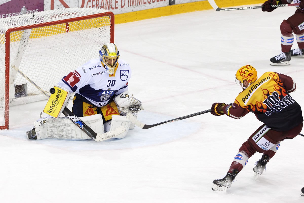 Zug's goaltender Leonardo Genoni, left, turns away the puck past PostFinance Top Scorer Geneve-Servette's forward Tanner Richard, right, during the third leg of the National League Swiss Cha ...