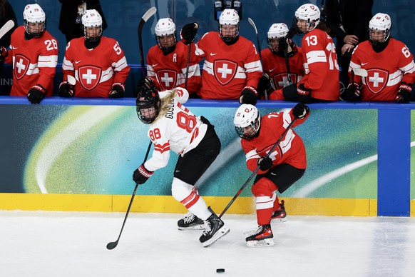 epa12714690 Lara Christen (R) of Switzerland vies for the puck .against Julia Gosling of Canada during the Women's Ice Hockey preliminary round match between Switzerland and Canada at the Milano  ...