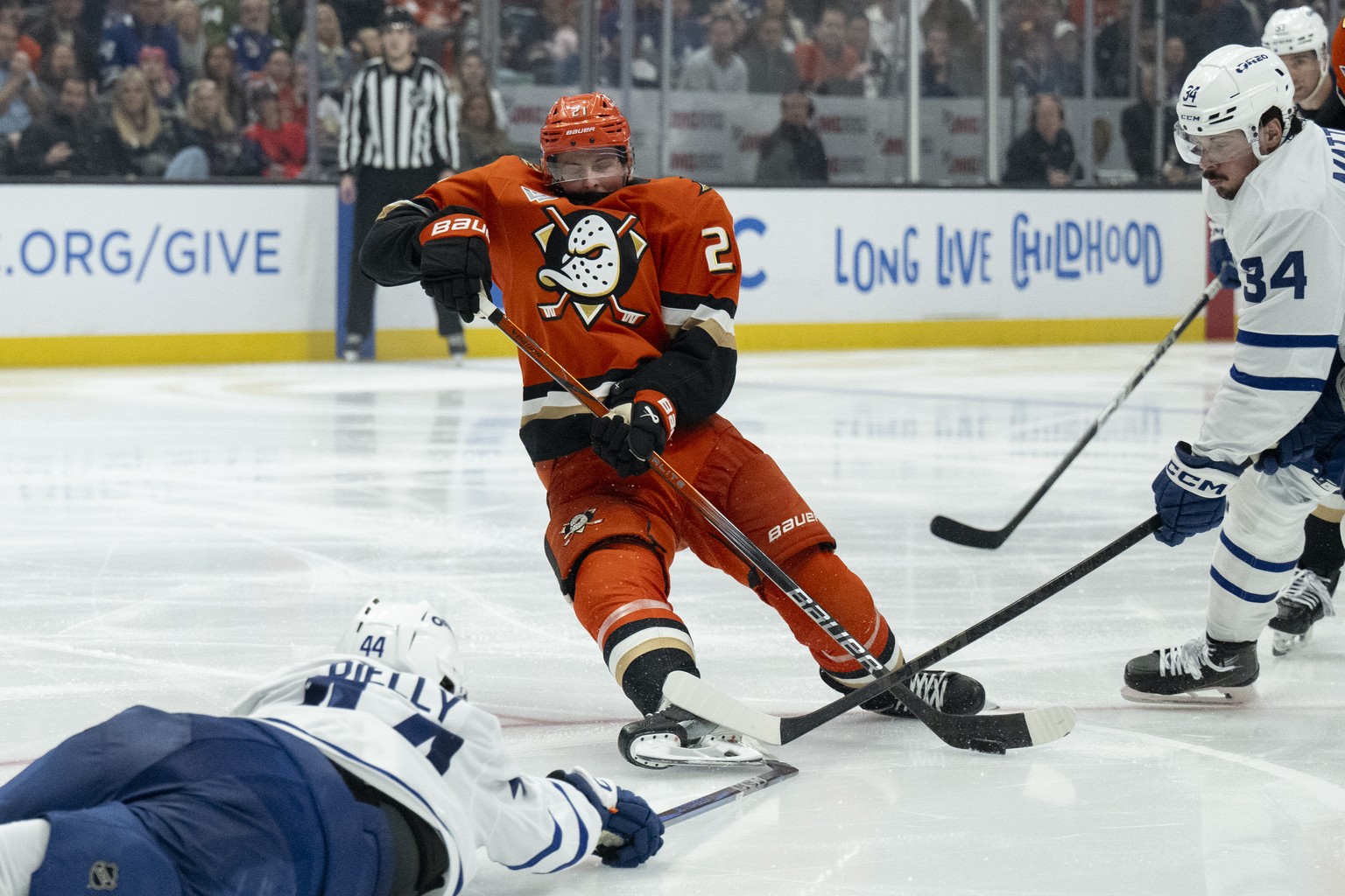 Anaheim Ducks defenseman Jackson LaCombe (2) is tripped by Toronto Maple Leafs defenseman Morgan Rielly (44) during the third period of an NHL hockey game, Sunday, March 30, 2025, in Anaheim, Calif. ( ...