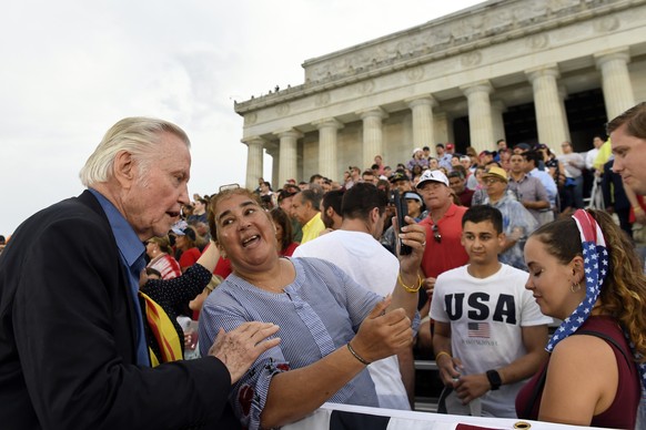 Actor Jon Voight, left, takes photos with guests as they wait for President Donald Trump to speak a an Independence Day celebration in front of the Lincoln Memorial in Washington, Thursday, July 4, 20 ...