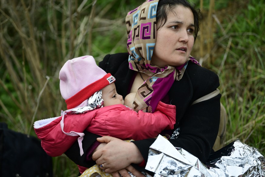 A woman breast feed her baby after the arrival of migrants at Eftalou beach, on the Greek island of Lesbos, after crossing on a dinghy the Aegean sea from Turkey, Sunday, March 1, 2020. Turkey&#039;s  ...