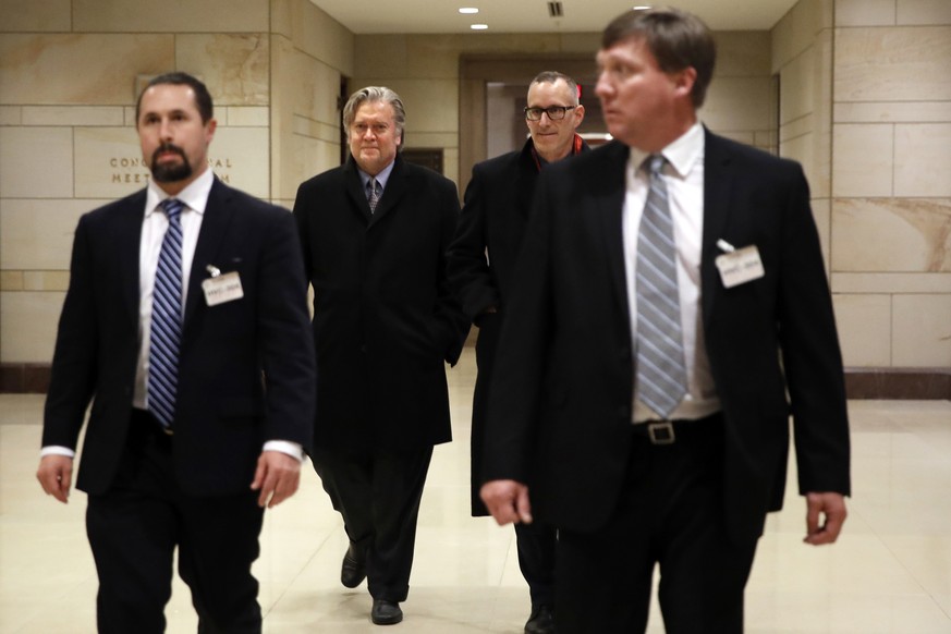 Former White House strategist Steve Bannon, second from left, is escorted from a House Intelligence Committee meeting where he was interviewed behind closed doors on Capitol Hill, Tuesday, Jan. 16, 20 ...