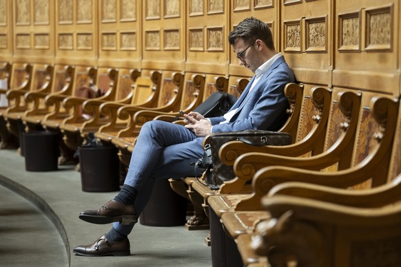 Andri Silberschmidt, FDP-ZH, sieht auf sein Handy waehrend der Fruehlingssession der Eidgenoessischen Raete, am Donnerstag, 29. Februar 2024 im Nationalrat in Bern. (KEYSTONE/Anthony Anex)