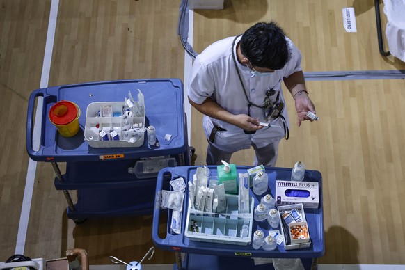 epa12289442 A nurse prepares a medicine cart inside a gymnasium repurposed as a ward for leptospirosis cases, at the National Kidney and Transplant Institute in Quezon City, Metro Manila, Philippines, ...