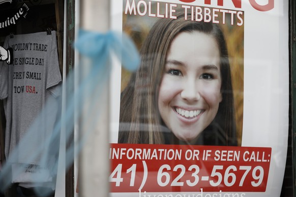 A poster for missing University of Iowa student Mollie Tibbetts hangs in the window of a local business, Tuesday, Aug. 21, 2018, in Brooklyn, Iowa. Tibbetts was reported missing from her hometown in t ...