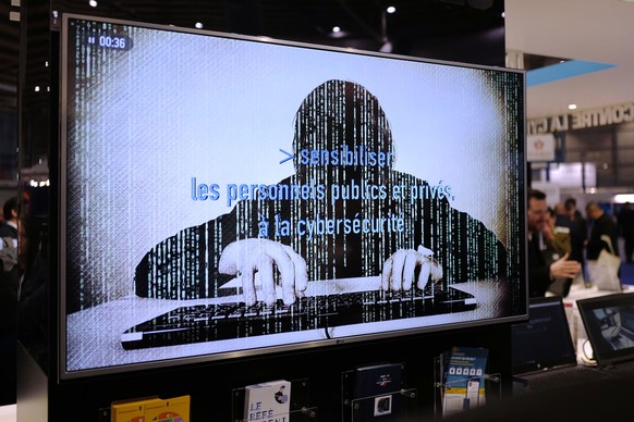 FILE - A television screen reads "Alerting public organizations and people to cybersecurity" at the International Cybersecurity forum in Lille, northern France,on Jan. 23, 2018. (AP Photo/Mi ...