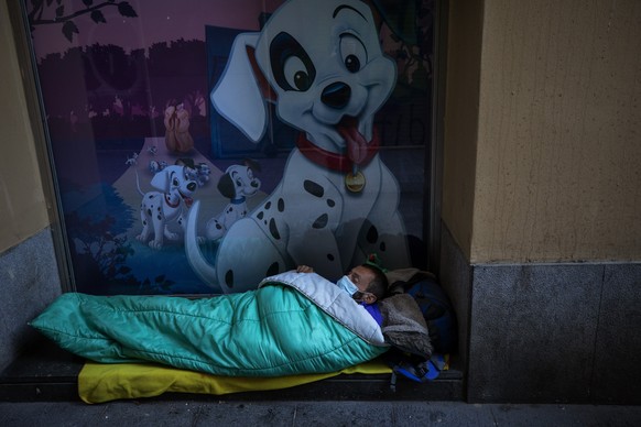 A homeless man sleeps in the doorway of a building, in Barcelona, Spain, March 15, 2020. (AP Photo/Emilio Morenatti)